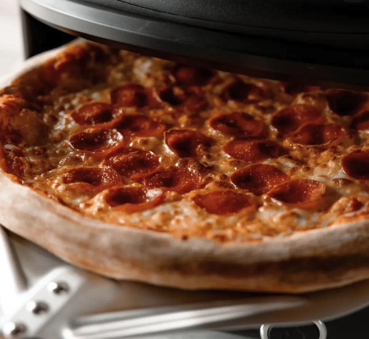 Festa Pizza Co Dual-Heat Rotating Pizza Oven, close-up of a pepperoni pizza on the rotating stone