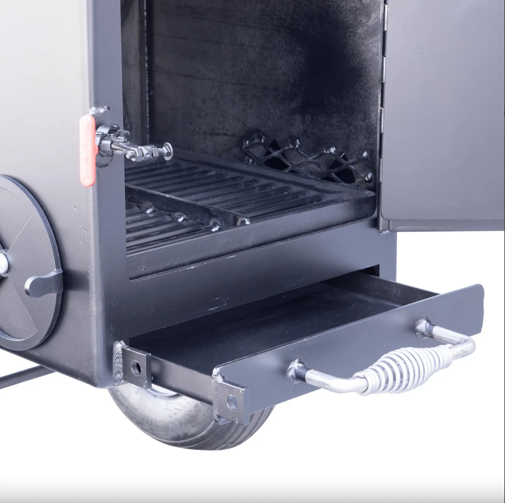 Meadow Creek SQ36 smoker firebox interior with cooking grate and pull-out ash drawer open.