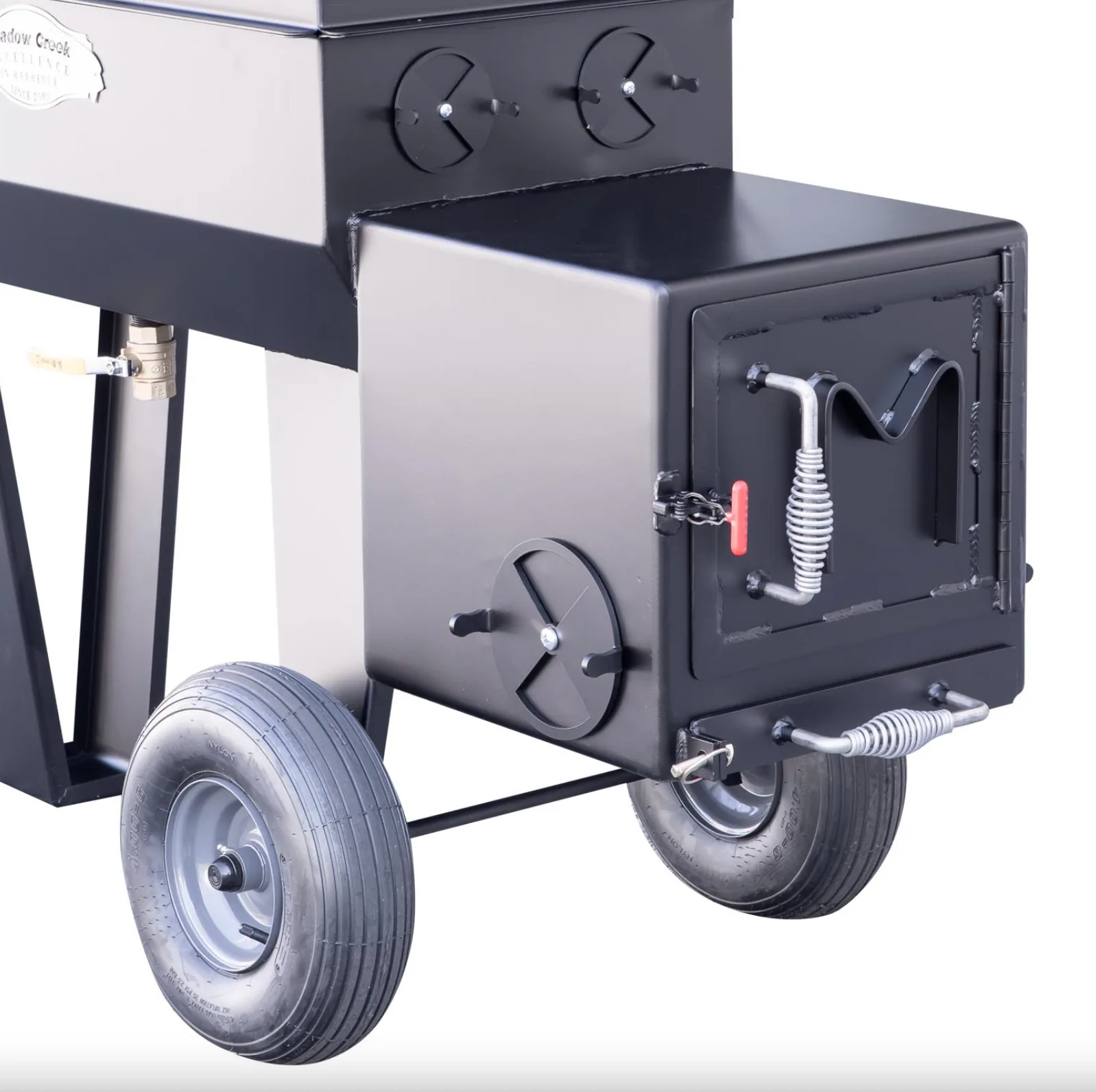 Meadow Creek SQ36 smoker side firebox with closed door, adjustable air vent, and large transport wheels.