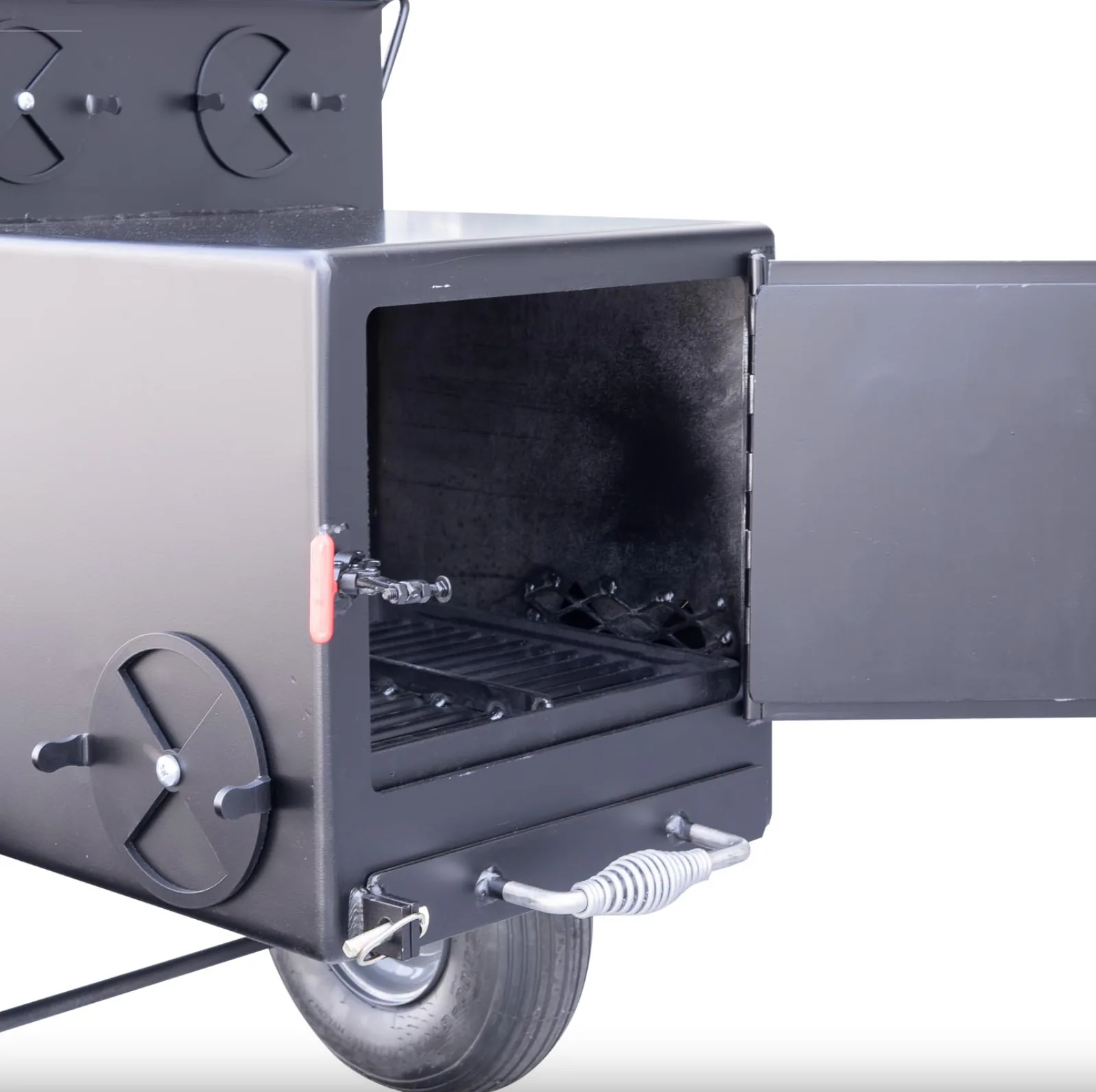 Angled view of Meadow Creek SQ36 firebox with open door, air vent, and coil-spring ash drawer handle.