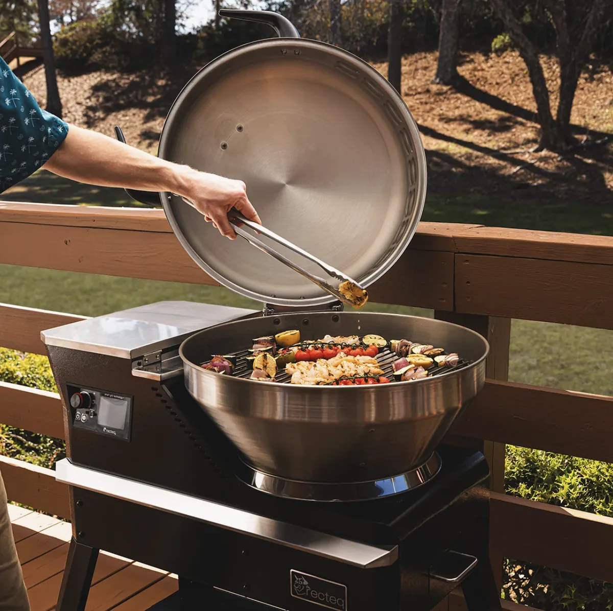 Recteq Bullseye Deluxe 380BD Pellet Grill, grilling shrimp and vegetable skewers on a deck