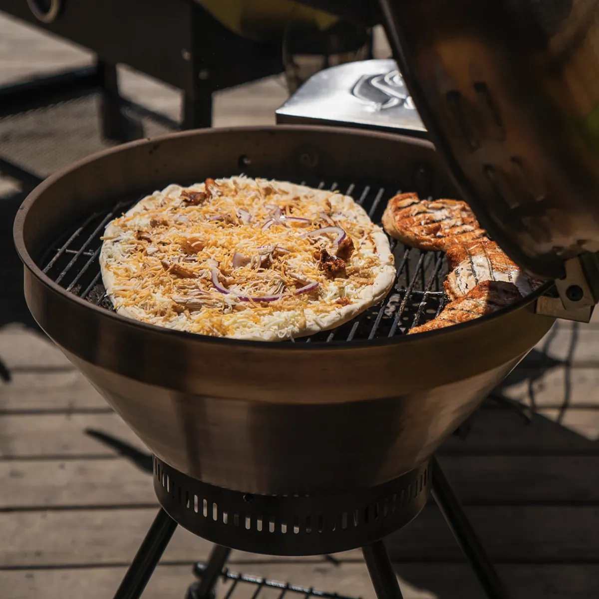 Recteq RT-B380 Bullseye Wood Pellet Grill, cooking a pizza and grilled chicken on the grate