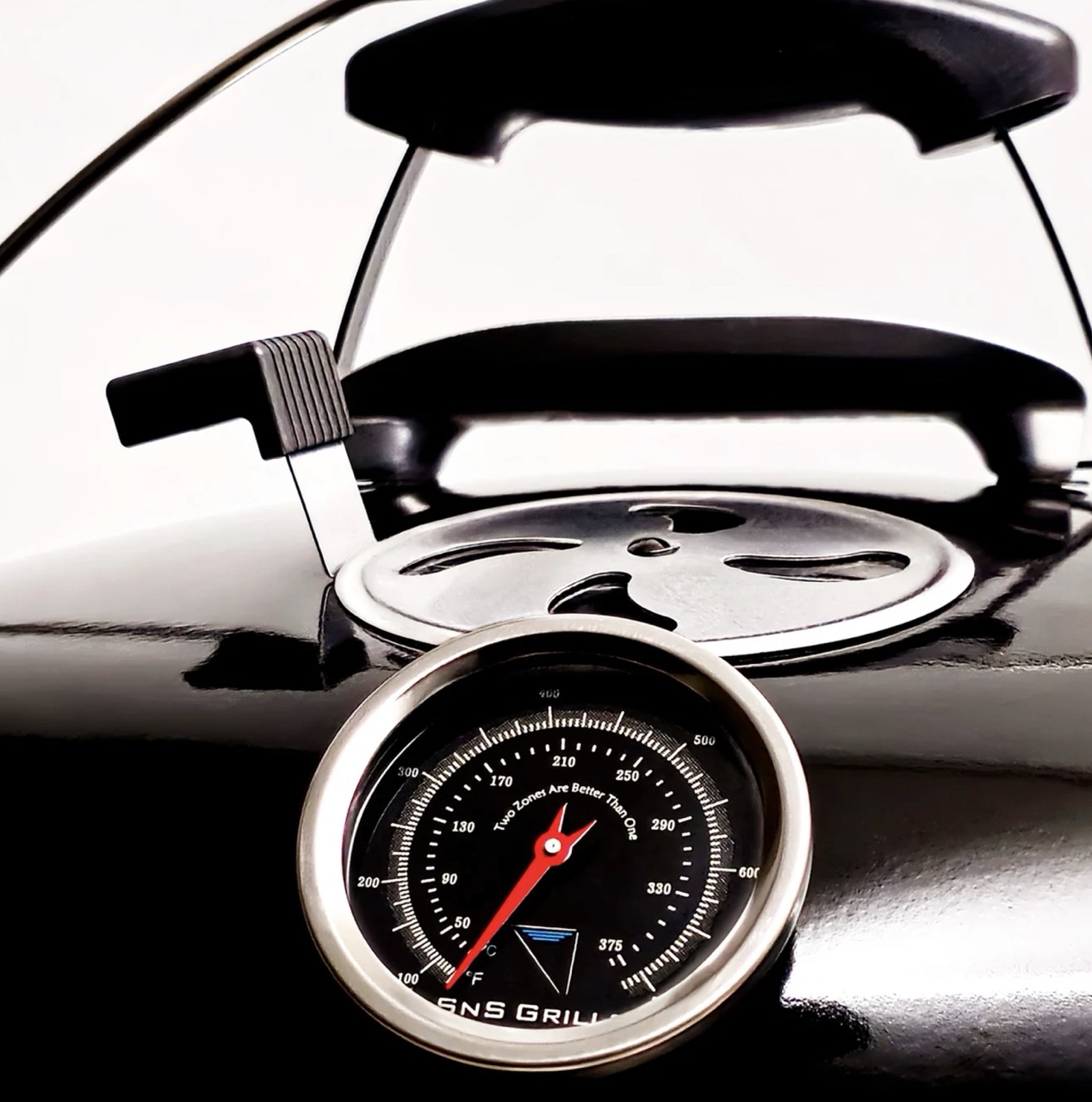 Close-up of SnS Grills Travel Kettle lid handle, adjustable air vent and built-in temperature gauge