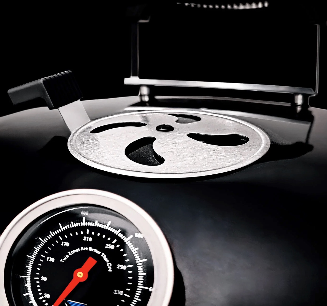 Close-up of SnS Slow 'N Sear Black Edition kettle grill lid and temperature gauge