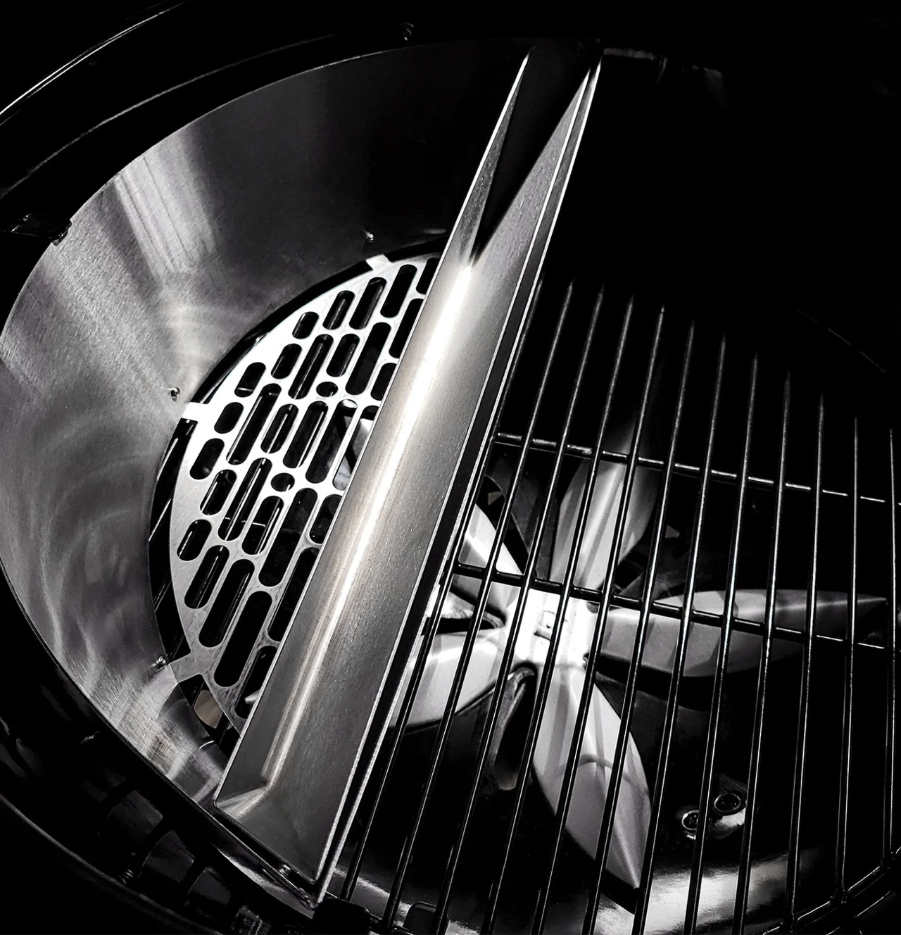 Close-up of the interior components of the SnS Slow 'N Sear charcoal kettle grill