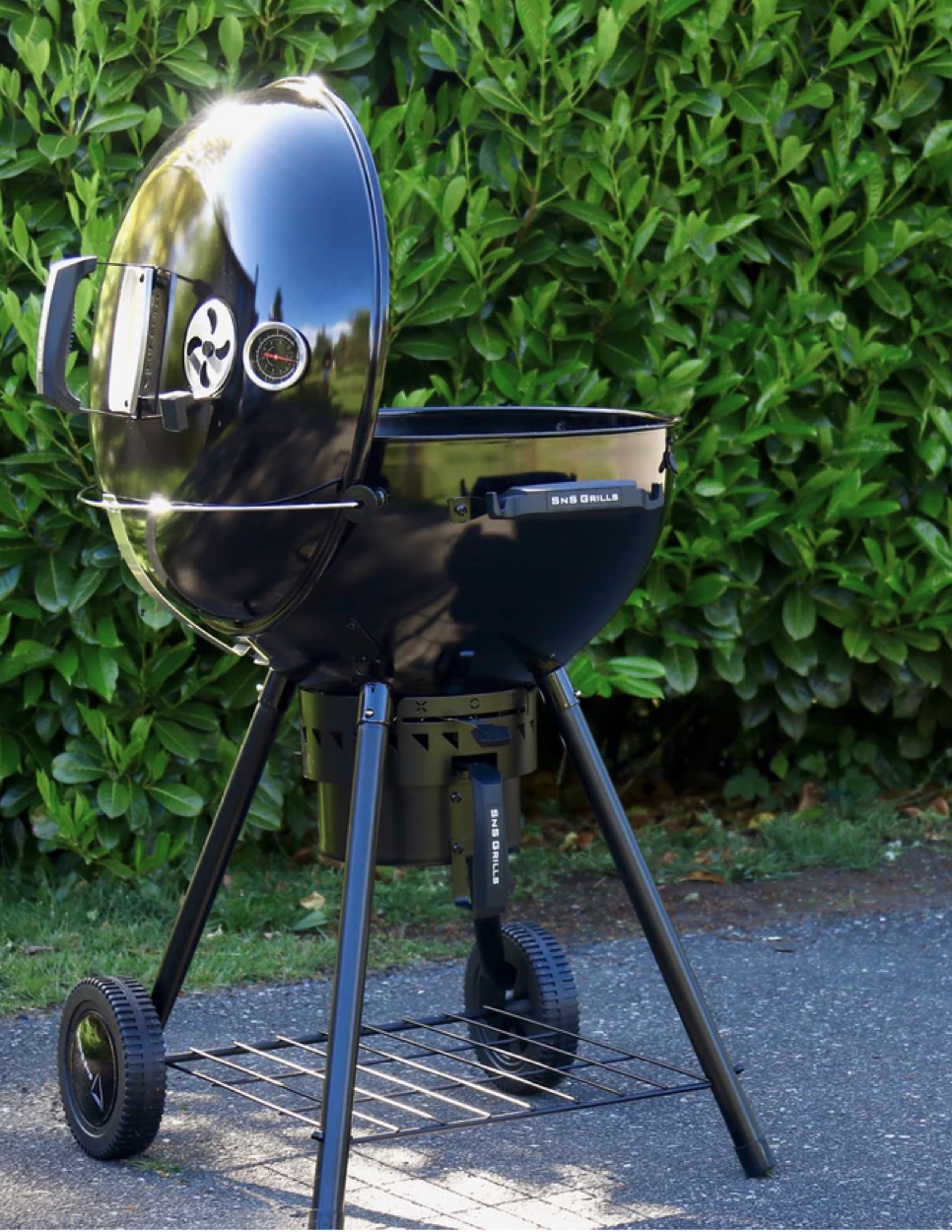 SnS Slow 'N Sear Black Edition charcoal kettle grill standing outdoors on a patio