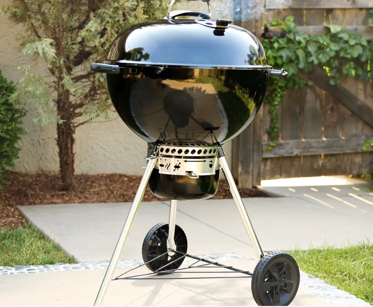 Weber Master-Touch 22" Charcoal Grill, in black on a backyard patio