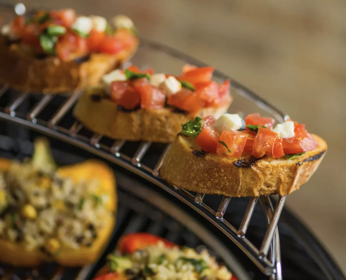 Weber Master-Touch 22" Charcoal Grill, bruschetta on the warming rack above stuffed peppers