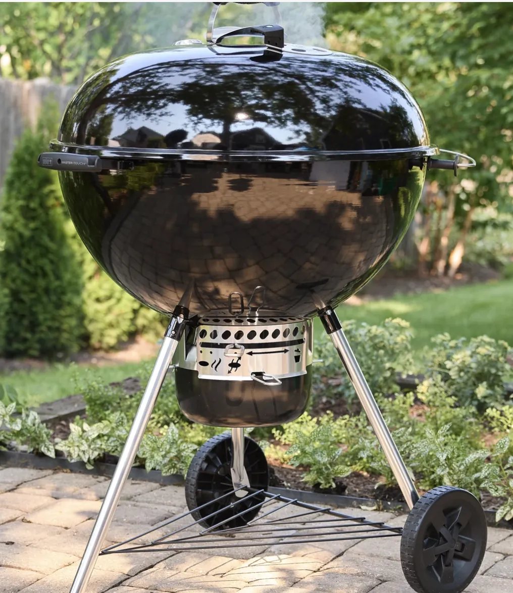 Weber Master-Touch 26" Charcoal Grill, in black on a backyard paver patio