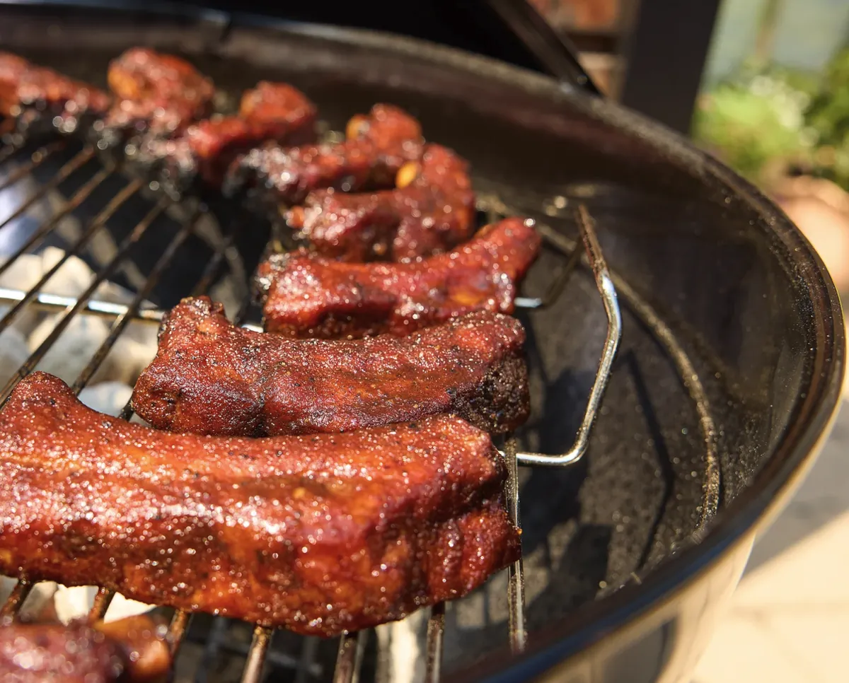 Weber Original Kettle 18" Charcoal Grill (Black), close-up of glazed ribs on the cooking grate